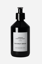 Sort flaske med pumpe, mærket "Urban Apothecary Coconut Grove", luksus hånd- og bodylotion.