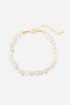 Armbånd med uregelmæssige, lyse ferskvandsperler og en guldfarvet lås med justerbar kæde.