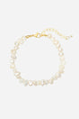 Armbånd med uregelmæssige, lyse ferskvandsperler og en guldfarvet lås med justerbar kæde.