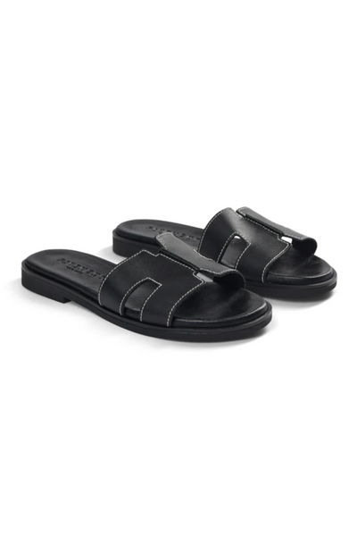 Sorte sandaler med flad sål og to brede stropper, der krydser over foden for et stilrent look.