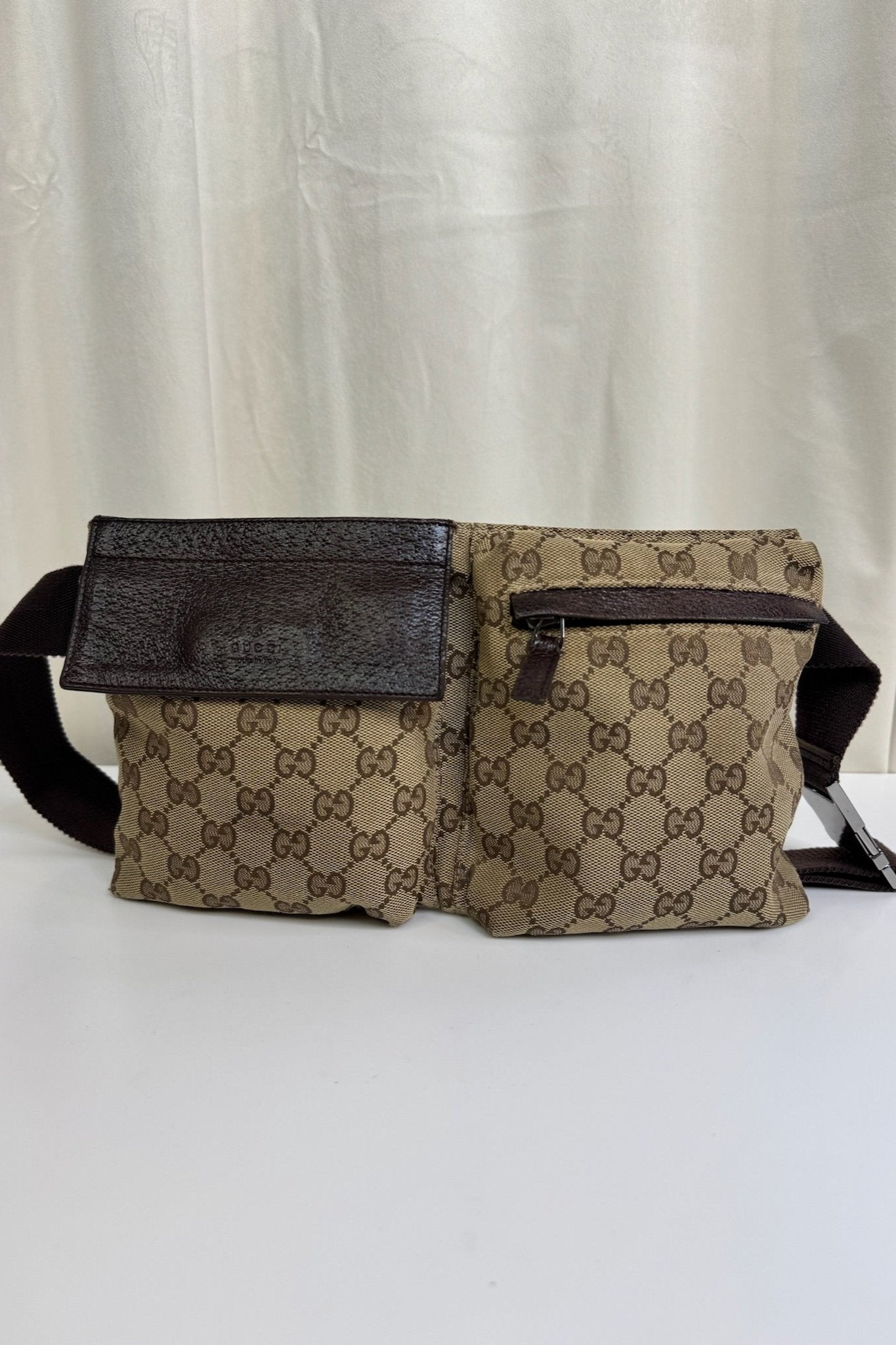 Gucci taske med logo, to rum med læderflap og lynlås. Mørk rem, kan bæres som bælte eller crossbody.