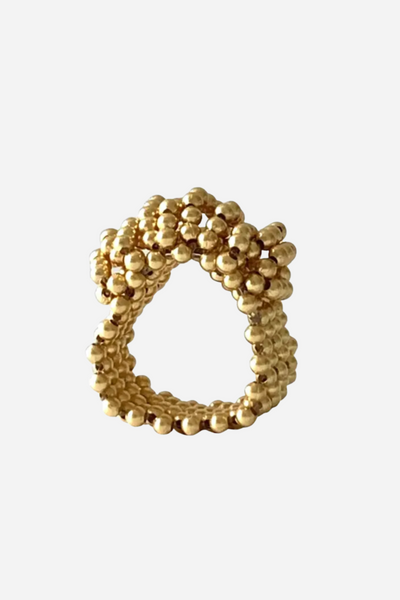 Gylden ring med tæt mønster af små runde kugler, der skaber en fyldig og dekorativ struktur.