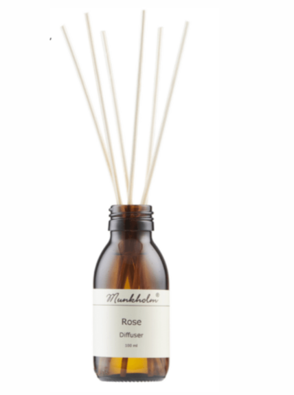 Brun glasflaske med duftpinde og etiket, der viser "Rose diffuser, 100 ml" fra Munkholm.