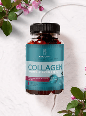 VitaYummy Collagen-glas med turkis etiket, omringet af lyserøde blomster på lys baggrund.